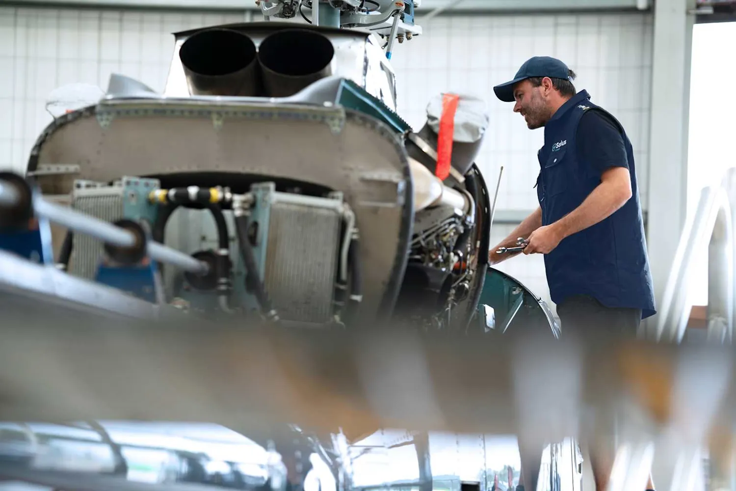 Helicopter undergoing maintenance inside a professional hangar